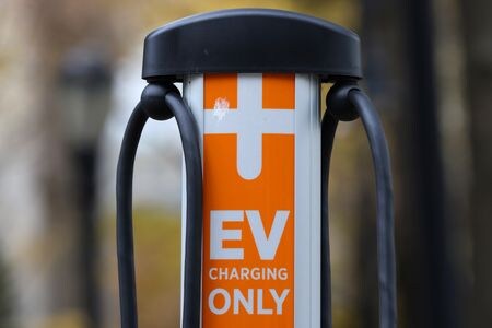 米運輸省は２７日、バイデン政権が掲げる電気自動車（ＥＶ）充電ステーション普及構想で、全米５０州と首都ワシントンとプエルトリコ（準州）で設置計画を承認し、カバーする高速道路は全長約７万５０００マイル（１２万０７００キロ）相当になったと発表した。NYのＥＶ充電ステーション、２０２１年１２月撮影（２０２２年　ロイター／Andrew Kelly）