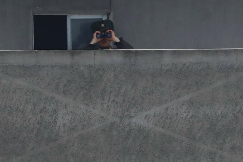 ８月１日、北朝鮮による相次ぐミサイル発射実験で朝鮮半島の緊張が高まるなか、タイに不法入国する北朝鮮人の数が、この数カ月間で急増している。写真は、中国との国境を監視する北朝鮮軍の兵士。中国遼寧省で４月撮影（２０１７年　ロイター/Aly Song）