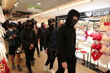 　１２月２６日、香港では数百人がショッピングモールをデモ行進した。写真は２５日、香港のショッピングモールを行進するデモ隊（２０１９年　ロイター/Lucy Nicholson）
