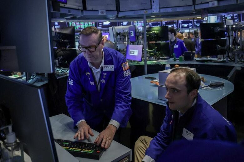 ニューヨーク証券取引所（NYSE）のフロアで働くトレーダーら。4月16日撮影。REUTERS/Jeenah Moon