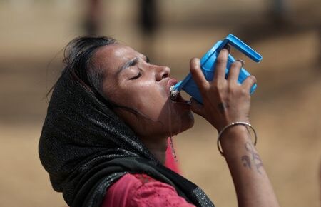 　４月１日、インド気象局（ＩＭＤ）は、４─６月に国内で発生する熱波が例年より多くなる公算が大きいとの見通しを示した。写真は暑い夏の日に水を飲む女性。インドのニューデリーで昨年６月撮影（２０２４　ロイター／Anushree Fadnavis）