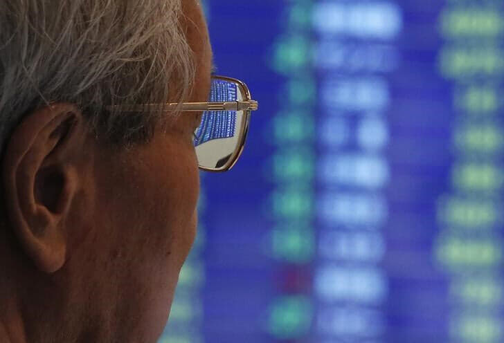 ７月１１日の東京市場で日経平均は史上最高値を更新し、４万２０００円の大台に初めて乗せた。写真は株価ボードを見る人。都内で２０１３年６月撮影（２０２４年　ロイター／Issei Kato）