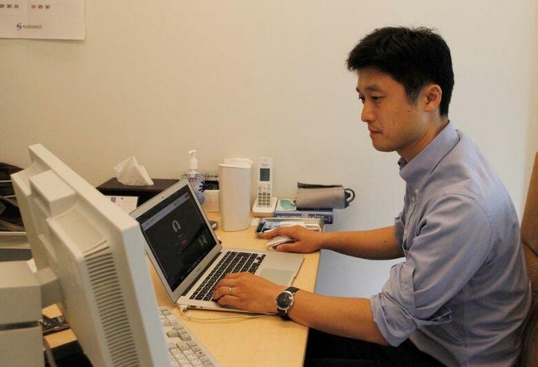 新型コロナウイルスの感染拡大に伴い、時限的に規制が緩和されたオンライン診療の活用が目に見えて広がっている。写真は九段下駅前ココクリニックの石井聡院長。１５日撮影（２０２０年　ロイター/Izumi Nakagawa）