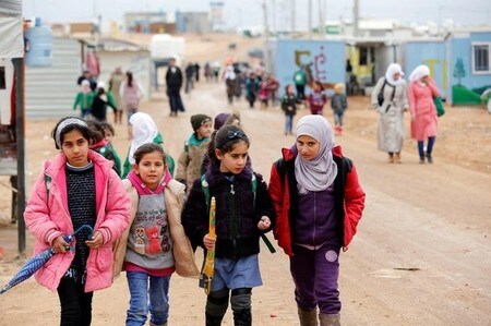 　１月２５日、トランプ米大統領が近日中に、避難民のための「安全地帯」をシリアに設ける計画を策定するよう国防総省と国務省に命じる見通しが明らかになった。写真は雨のなかを学校に向かうシリア難民の子供達。ヨルダンのマフラクにある難民キャンプで昨年１２月撮影（２０１７年　ロイター／Muhammad Hamed）