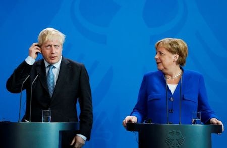 ７月７日、英首相官邸の報道官によると、ジョンソン英首相（写真左）は、メルケル独首相（同右）との電話会談で、欧州連合（ＥＵ）との将来の関係について早期の合意を目指す姿勢を強調する一方、貿易交渉で合意できない場合、「オーストラリア条件」で離脱する用意があるとの立場を伝えた。ベルリンで２０１９年８月撮影（２０２０年　ロイター/Fabrizio Bensch）