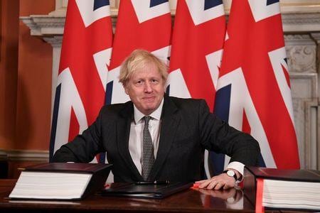 英政府は、環太平洋経済連携協定（ＴＰＰ）への参加を２月１日に正式に申請すると発表した。写真は２０２０年１２月、ロンドンの英首相官邸で英ＥＵ通商協定に署名するジョンソン首相。代表撮影（２０２１年　ロイター）
