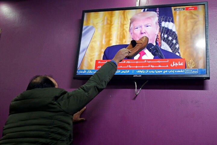TV画面のトランプ大統領の顔に靴を叩きつけるパレスチナ男性（1月28日）　Mussa Qawasma-REUTERS