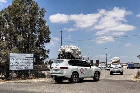 パレスチナ自治区ガザ地区に食糧を輸送していた国連のトラックが足止めされ、略奪を受けたことが分かった。写真は２８日、ガザ南部のケレム・シャローム検問所を通過する車両（２０２５年　ロイター/Shafiek Tassiem）
