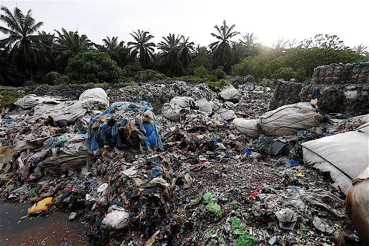 マレーシアの違法プラスチック処理施設が、ヤシ油農園のそばにスクラップを捨て置いている。Lai Seng Sin - REUTERS