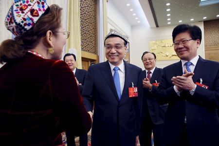 　３月１０日、中国の李克強首相（中央）は政府高官らに対し、新疆ウイグル自治区の中心部における開発に尽力する必要があるとの見解を示した。写真左の女性は新疆ウイグル自治区の使節、右は張春賢同自治区党委員会書記。提供写真（2016年　ロイター）