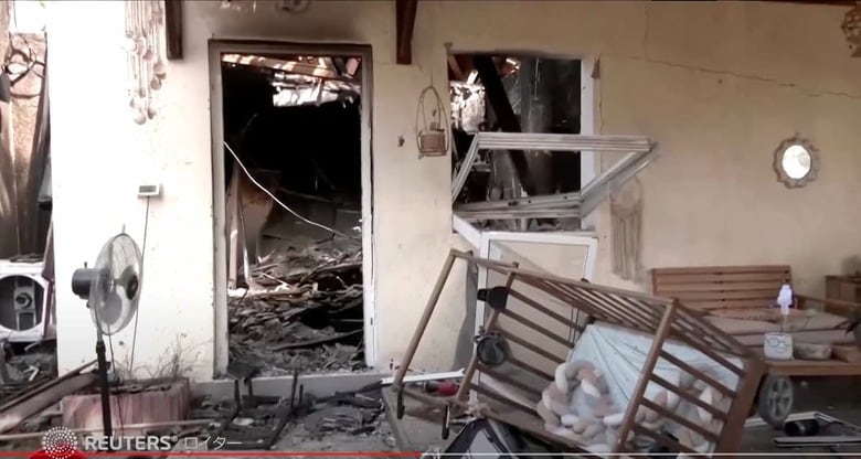 路上のあちこちに遺体が横たわり、バスケットボールコートの外には遺体の収容袋が並べられ、破壊されたベビーベッドが全焼した家の外に放置されている。Reuters Japan / YouTube