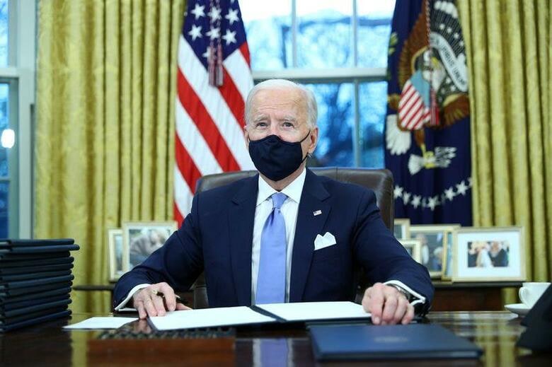 バイデン米大統領は就任初日の1月20日、15の大統領令への署名を開始した。環境問題や新型コロナウイルス対策などトランプ前政権の政策を転換する。ホワイトハウスで撮影（2021年　ロイター/Tom Brenner）
