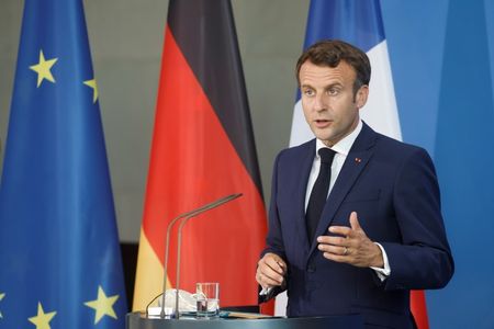 ６月１８日、フランスのマクロン大統領は、欧州が目標としている防衛の自律性は北大西洋条約機構（ＮＡＴＯ）との共存が可能との見解を示した。写真は同日、ベルリンでドイツのメルケル首相と共同記者会見に臨むマクロン氏（２０２１年　ロイター／Axel Schmidt）