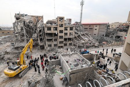 　３月１３日、イスラエル国防軍（ＩＤＦ）は、「ライオンの咆哮」作戦の一環として、空軍がこの１日でイラン西部・中部で２００以上の標的を攻撃したと発表した。写真は、米国とイスラエルがイランとの対立を深める中、テヘランの空爆現場に集まる人々。１２日撮影（２０２６年　ロイター/Alaa Al Marjani）