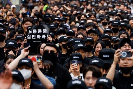 韓国サムスン電子の労働組合が７日、初のストライキを実施した。アナリストによると、直ちに半導体の生産や出荷に影響を与える可能性は低いものの、人工知能（ＡＩ）で使用されるチップの出遅れを取り戻そうとしている同社に打撃となる。写真はプラカードを持つ労組メンバーら。ソウルで５月撮影。（2024年 ロイター/Kim Soo-hyeon）