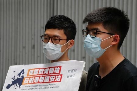 　７月２日、香港民主派による２０１４年の大規模デモ「雨傘運動」を主導した羅冠聡（ネイサン・ロー）氏（写真左）は、フェイスブックへの投稿で香港を離れたことを明らかにした。写真右は黄之鋒（ジョシュア・ウォン）氏。香港で６月撮影（２０２０年　ロイター／Tyrone Siu）