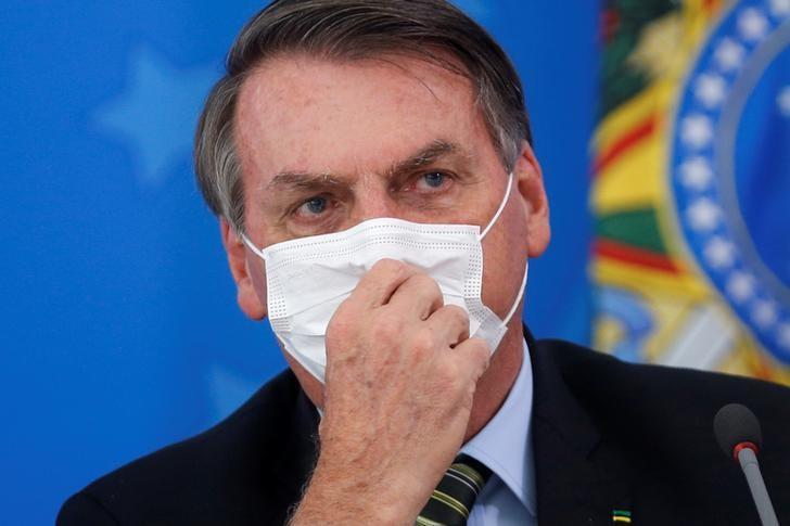 ブラジル政府は、新型コロナウイルスの感染拡大を受け、非常事態を宣言した。写真はマスクを付けているボルソナロ大統領。3月18日撮影（2020年　ロイター/Adriano Machado）