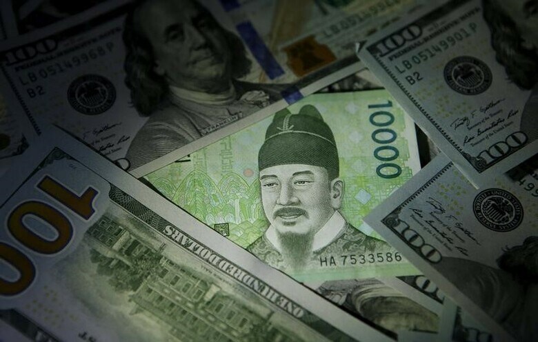 ３月２７日、米国政府は、韓国との自由貿易協定（ＫＯＲＵＳ）見直しについて、韓国政府による競争的通貨切り下げを阻止する付属文書を追加するほか、韓国が自動車や製薬分野で譲歩することで合意したと明らかにした。写真は米ドル紙幣と韓国ウォン紙幣。ソウルで２０１５年１２月撮影（２０１８年　ロイター／Kim Hong-Ji）