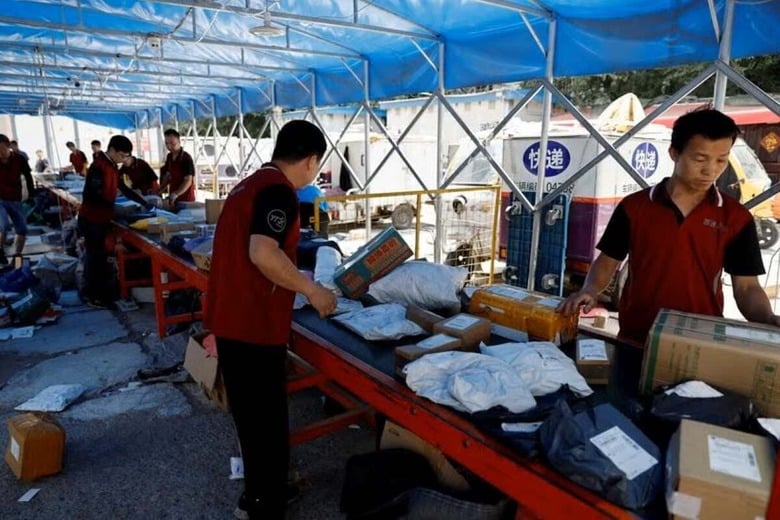 ６月２５日、中国の大型ネット通販セール「６１８」が期待外れに終わったことを受け、小売業者の目先の見通しや景気の先行きに暗雲が生じている。写真は北京でベルトコンベアーに流れる宅配便を仕分けする作業員ら。１２日撮影（２０２４年　ロイター/Tingshu Wang）