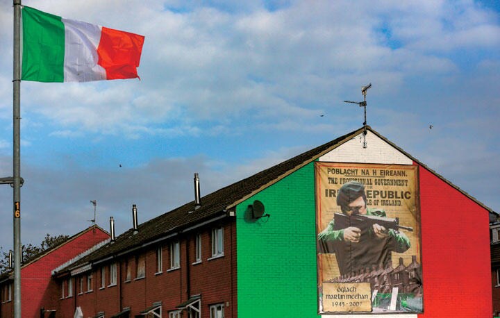 北アイルランドの首府ベルファストではアイルランドの旗がはためき、建物の壁にIRA戦闘員が描かれている　CATHAL MCNAUGHTONーREUTERS