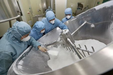 中国国家医療保障局（ＮＨＳＡ）は２８日、来年３月に医療保険適用医薬品に加わる１００超の医薬品について、製薬会社が平均５０％程度の薬価引き下げに同意したと発表した。写真は新型コロナウイルスの治療に効果があるとされる薬剤の生産に取り組む中国の技術者たち。今年２月２７日、南通市で撮影。（２０２０年　チャイナデイリー提供）