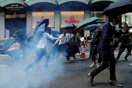 １１月１１日、米政府当局者は、香港で発生したデモ隊と警察の衝突について、「殺人兵器の不当な使用」があったとして非難するとともに、警察とデモ隊の双方に事態の段階的な収拾を呼びかける声明を発表した。写真は香港の金融街で警官隊の催涙弾から逃れる人々（２０１９年　ロイター/Tyrone Siu）