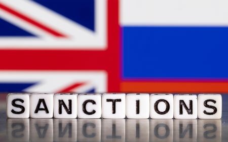 　２月２４日、英国政府は、ウクライナ戦争初期以来最大規模とする対ロシア制裁を発表した。写真は、英国旗とロシア国旗の前に置かれた「制裁」の文字。２０２２年２月、ボスニア・ヘルツェゴビナのゼニカ市で撮影（２０２５年　ロイター/Dado Ruvic）