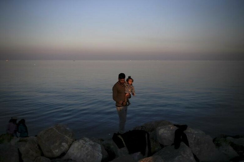 １１月５日、欧州委員会は経済見通しのなかで、２０１７年までに３００万人の難民が域外からＥＵ加盟国にやってくると見込んだ。難民が社会の中で労働力として融合すれば、経済成長を押し上げ、長期的には財政改善につながる可能性があるとしている。写真は同日、ギリシャのレスボス島の海岸のシリア難民の親子（２０１５年　ロイター/Alkis Konstantinidis）