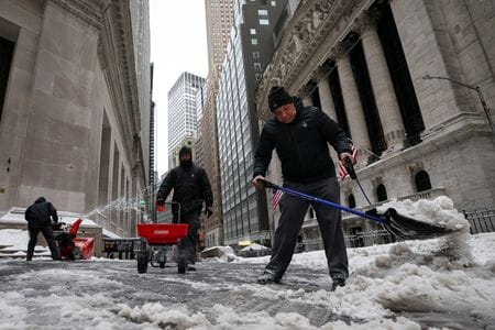 米ニューヨーク証券取引所（ＮＹＳＥ）前で雪下ろしをする作業員。２６日撮影。REUTERS/Brendan McDermid