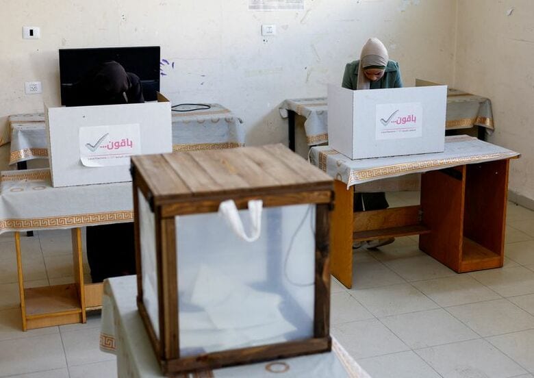 写真は投票用紙に記入する人々。4月25日、ガザ中部デイル・アルバラの投票所で撮影。REUTERS/Mahmoud Issa