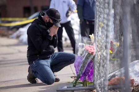 米コロラド州ボルダーのスーパーマーケットで１０人が犠牲となった銃乱射事件で、警察当局は２３日、現場で拘束した２１歳の男を殺人容疑で起訴したと発表した。写真は２３日、事件のあった現場で花と祈りを捧げる男性（２０２１年　ロイター／Alyson McClaran）