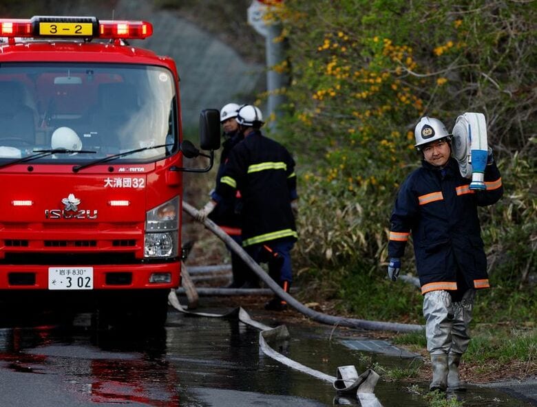 写真は山火事が発生した岩手県大槌町の現場で、消火ホースを運ぶ芳賀諒太さん。4月26日撮影。REUTERS/Kim Kyung-Hoon
