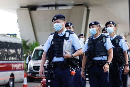 　香港の裁判所は２２日、国家安全維持法（国安法）違反で逮捕された民主派新聞「蘋果日報（アップル・デイリー）」の社員４人の保釈請求を却下した。写真は、裁判所周辺をパトロールする警察官（２０２１年　ロイター/Tyrone Siu）