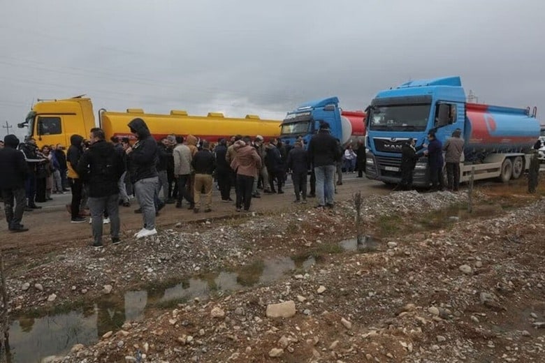 ６月５日、イラク石油省は、北部のクルド地域からの石油密輸が続いていることについて、クルド自治政府（ＫＲＧ）に法的責任があると主張し、あらゆる法的措置を講じる権利を留保すると表明した。写真はイラク・スレイマニヤ近郊のアルバットで石油を運ぶトラックの前で道路を封鎖するクルド人デモ隊。２月撮影（２０２５年　ロイター/Ako Rasheed