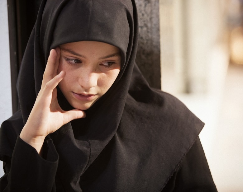 カフェの前の通りに体重計を置き、街行く人々の体重を量って代金をもらっていたファラシュテ。ふとした瞬間に見せる表情が彼女の成長を感じさせた（12歳）