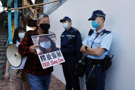 中国・上海の裁判所は２８日、新型コロナウイルス流行のピーク時に湖北省武漢から実態を報じた市民記者の張展氏（３７）に「混乱を誘発した」として懲役４年の判決を言い渡した。写真は香港で張氏の釈放を求める支持者ら（２０２０年　ロイター/TYRONE SIU）