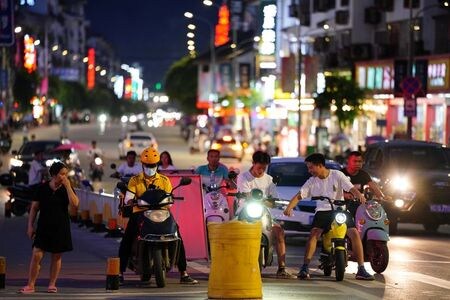 ４月２６日、    中国の独占禁止当局である国家市場監督管理総局（ＳＡＭＲ）は同国の食品デリバリー大手、美団に対する独禁法調査を開始したと発表した。写真は２０２０年７月、陽朔の街頭で配達に向かう美団の配達員（２０２１年　ロイター/Thomas Suen）