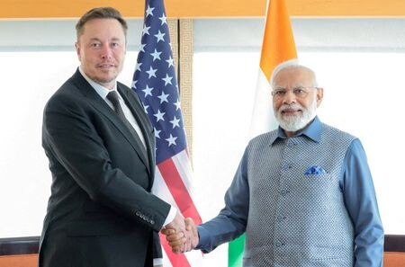 　関係筋によると、インド政府は新たなＥＶ政策として、同国内での生産を確約した自動車メーカーの自動車を輸入する際に適用する関税を引き下げることを検討している。写真はニューヨークで６月、テスラのマスクＣＥＯ（左）と握手するインドのモディ首相。提供写真（２０２３年　ロイター／India\'s Press Information Bureau）