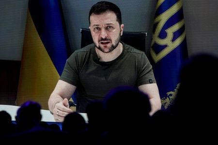 ５月２５日、ウクライナのゼレンスキー大統領は、ロシアとの戦争を終結させるために同国が領土を巡り譲歩すべきだとの案に強く反発した。写真は２３日、スイス・ダボスで開催されたダボス会議でビデオ演説するゼレンスキー氏（２０２２年　ロイター/Arnd Wiegmann）