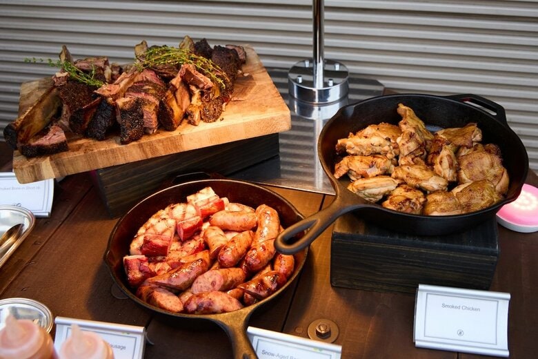 スモークチキンやソーセージ、骨付き肉など、テキサスバーベキューらしい豪快な肉料理が並ぶ「Splash!」のメニュー　井出友樹
