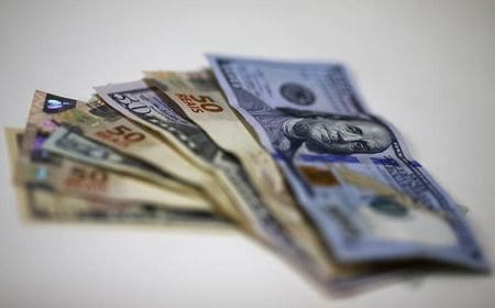 　１２月２８日、終盤のニューヨーク外為市場でドルは小幅安。ロンドン市場が休みで取引が薄い中、ドルを買い持ちにしている市場参加者の一部が年末に向けて利益確定売りを出し、ドルは主要通貨に対して約１週間ぶり安値水準で推移した。写真はドルとブラジル・レアルの紙幣、リオデジャネイロで９月撮影（２０１５年　ロイター／Ricardo Moraes）