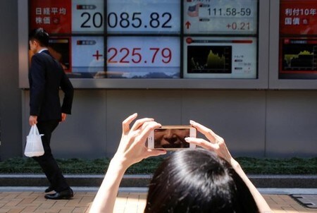 　６月２日、日経平均がようやく２万円の大台を突破した。良好な景気や堅調な企業業績見通しが、米株最高値更新という追い風を受けて再評価された形だが、約４週間、大台手前で「じらされた」エネルギーが噴き出した面もある。都内の証券会社で撮影（２０１７年　ロイター/Toru Hanai）