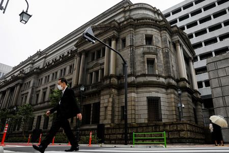 　４月１５日、日銀は２７―２８日の金融政策決定会合で、２０２２年度物価見通しの上方修正を検討する見通し。写真は日銀の前を通る男性。都内で２０２０年５月撮影（２０２２年　ロイター/Kim Kyung-Hoon）