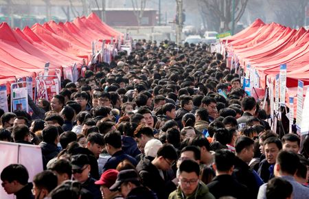 　８月２１日、  中国では失業者の増大に伴って、数百万人の大学新卒者が空前の就職氷河期に直面している。写真は２０１８年２月、石家庄市で開かれた就職フェアを訪れた人々（２０２４年　ロイター/Jason Lee）