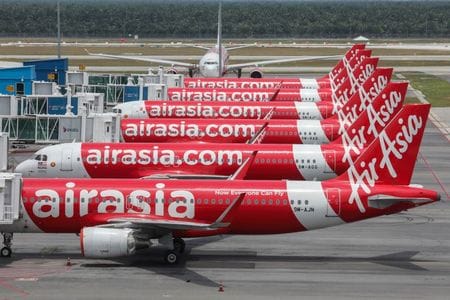 格安航空会社（ＬＣＣ）のエアアジア・ジャパンは５日、事業廃止を決めたと発表した。新型コロナウイルス感染拡大による旅行需要の低迷で事業運営に大きな困難が生じたという。写真は、エアアジアグループの飛行機。クアラルンプール国際空港で４月撮影。（2020年 ロイター/Lim Huey Teng ）