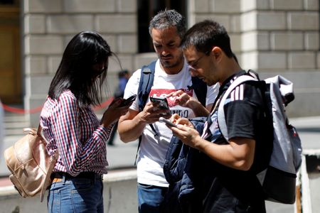 People look at their smartphones in lower Manhattan in New York City, U.S., May 8, 2019. REUTERS/Mike Segar