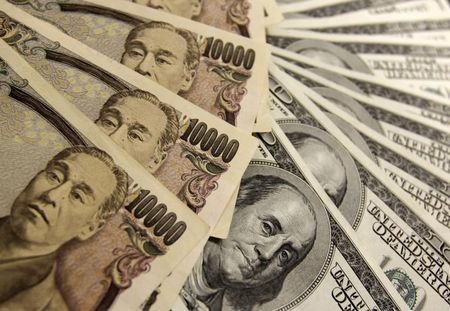 ５月２６日、ニューヨーク外為市場では、ドルが主要通貨に対して１％を超える大幅上昇となった。好調な米経済指標を受け、米連邦準備理事会（ＦＲＢ）の年内利上げ観測が強まった。写真は、１万円札とドル紙幣、２００９年１１月撮影（２０１５年　ロイター／Yuriko Nakao）