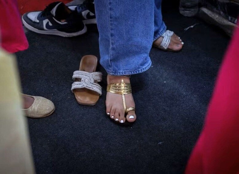イタリアの高級ファッションブランド、プラダがインドの伝統的なサンダル「コルハプリ」（ヒンドゥー語ではチャッパル）のデザインを無断で使用したと激しい批判を浴びた。写真はコルハプリを試す女性。７月１日、ニューデリーで撮影（２０２５年　ロイター/Bhawika Chhabra）