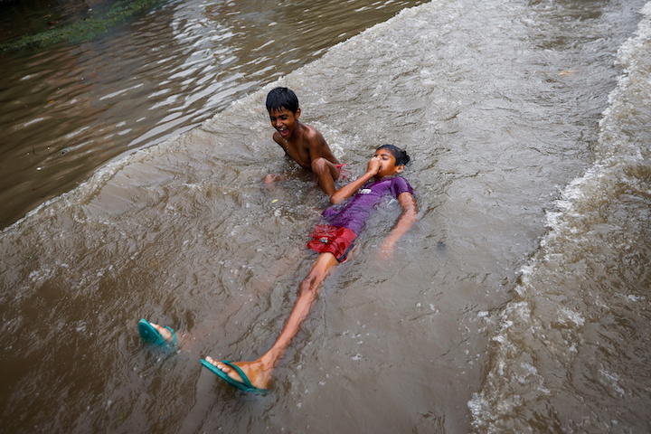 豪雨で氾濫した水で遊ぶインドの子どもたち（9月1日、ニューデリー）　Adnan Abidi-REUTERS