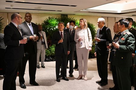 韓国の李鐘燮国防相は１２日、シンガポールで開催中のアジア安全保障会議（シャングリラ対話）で講演し、防衛力を強化するとともに日米と緊密に協力して北朝鮮の核とミサイルの脅威に対抗していくと述べた。写真は昼食会の前に各国の参加閣僚と懇談する李国防相（左から３番目）。６月１１日、シンガポールで撮影（２０２２年　ロイター/Caroline Chia）